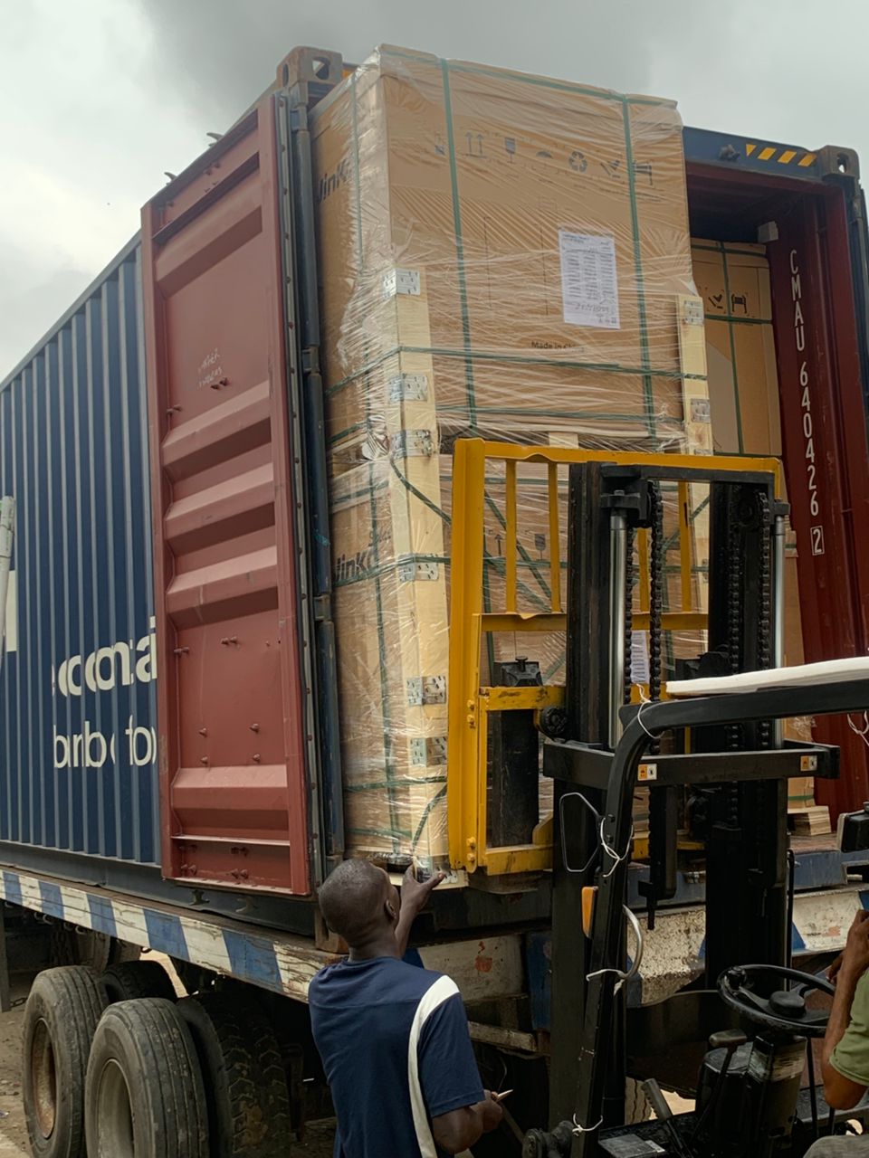 Pallets of solar panels being offloaded from a shipping container